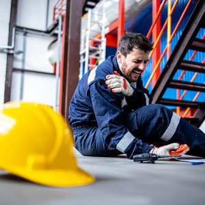 Injured oil and gas worker holding shoulder after workplace accident.